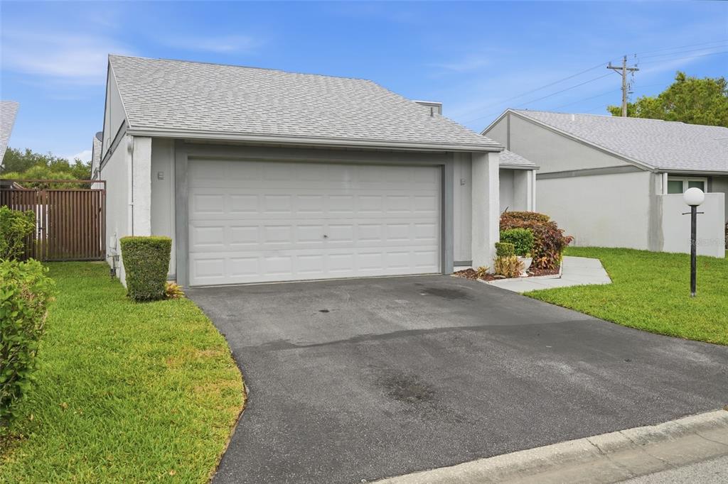 A single-story house with a gray shingled roof, a two-car garage, and a paved driveway — 18441 ORANGECREST COURT, LEHIGH ACRES, FL
