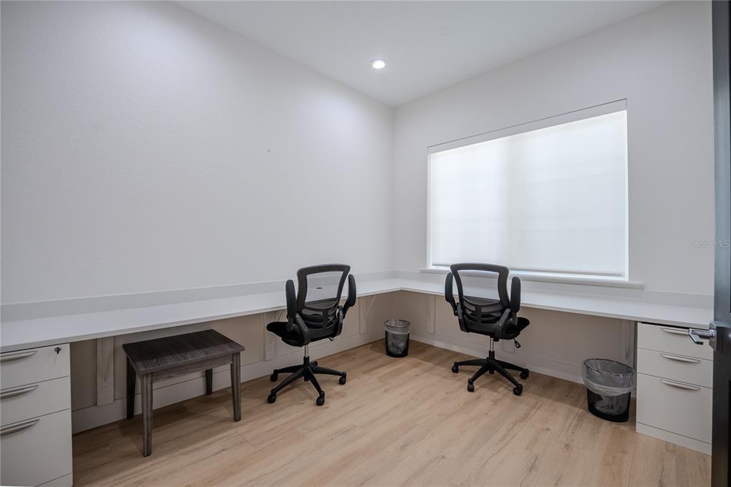 A home office features an L-shaped white desk, two rolling chairs, and light wood flooring — 6601 SW 80TH AVENUE, OCALA, FL
