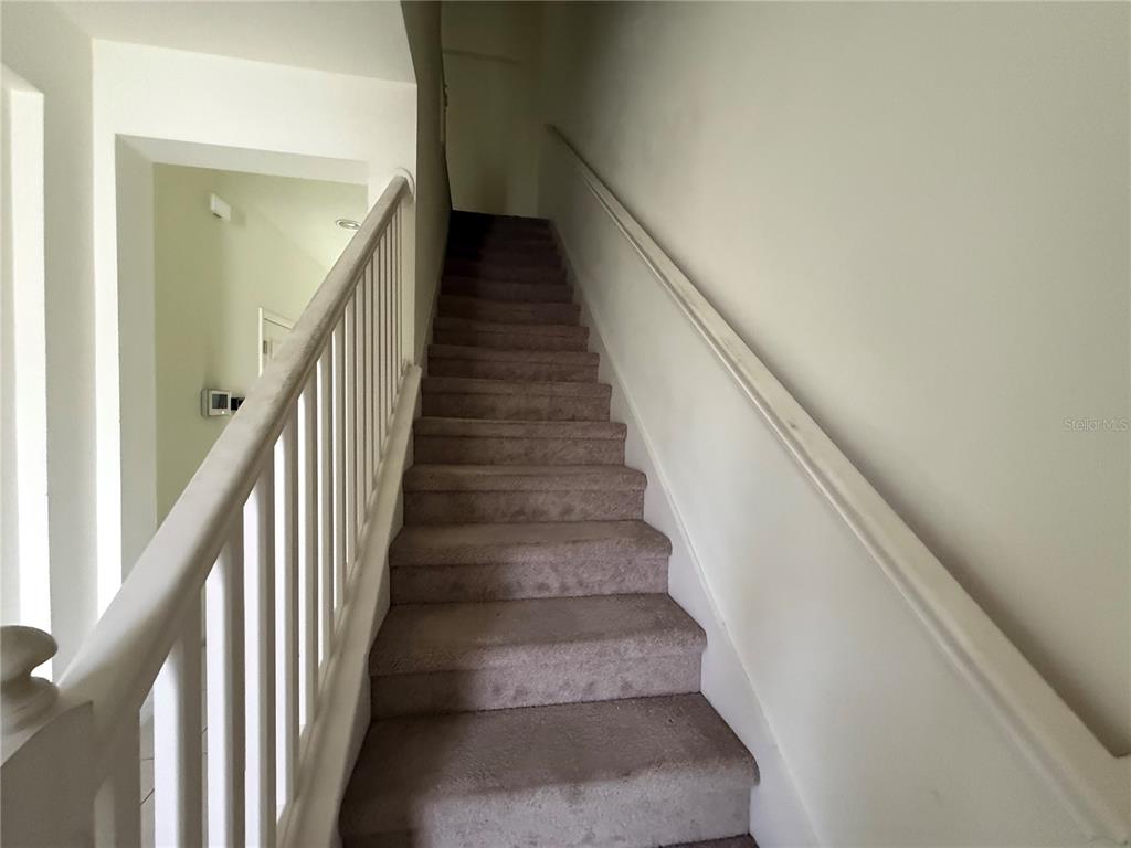 A carpeted staircase with a white wooden railing leads to an upper floor — 6843 40TH LANE N, PINELLAS PARK, FL