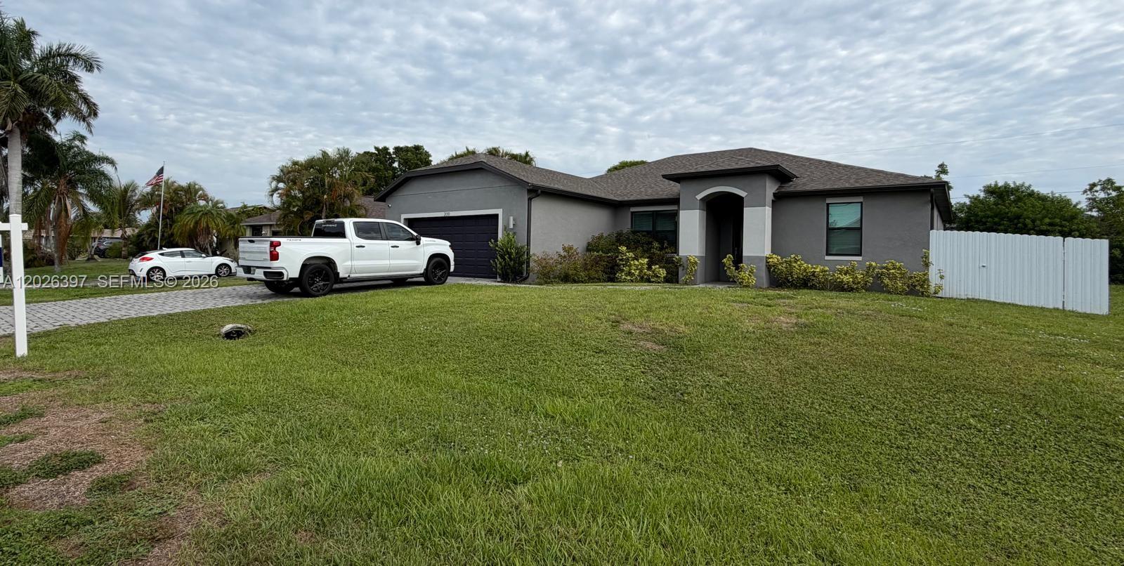 A single-story gray house with a two-car garage and a white truck parked outside — 209 SE 26th Ter, Cape Coral FL 33904, CAPE CORAL, FL