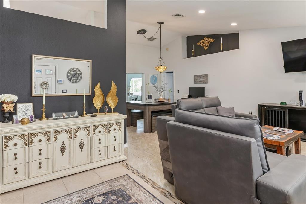A living room features a white ornate sideboard, a grey sofa, and a dining area — 26550 VALPARAISO DRIVE, PUNTA GORDA, FL