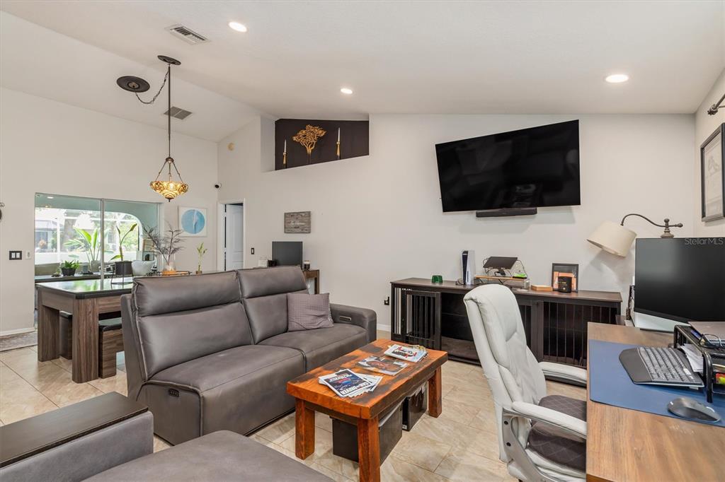 A living room features a grey sofa, a wooden coffee table, and a desk area — 26550 VALPARAISO DRIVE, PUNTA GORDA, FL