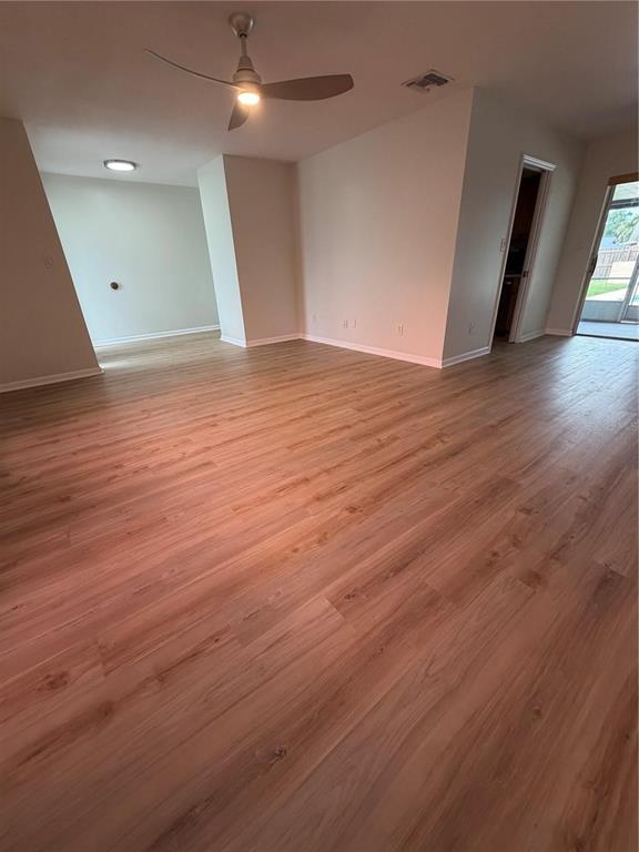 An open-concept living area features light wood-look flooring, a ceiling fan, and a sliding glass door — 3024 BLOWN FEATHER LANE, MULBERRY, FL