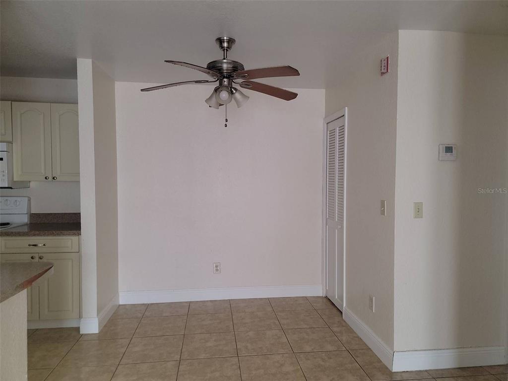 A dining area with tile flooring, a ceiling fan, and a white louvered closet door — 2550 N ALAFAYA TRAIL UNIT 2103, ORLANDO, FL