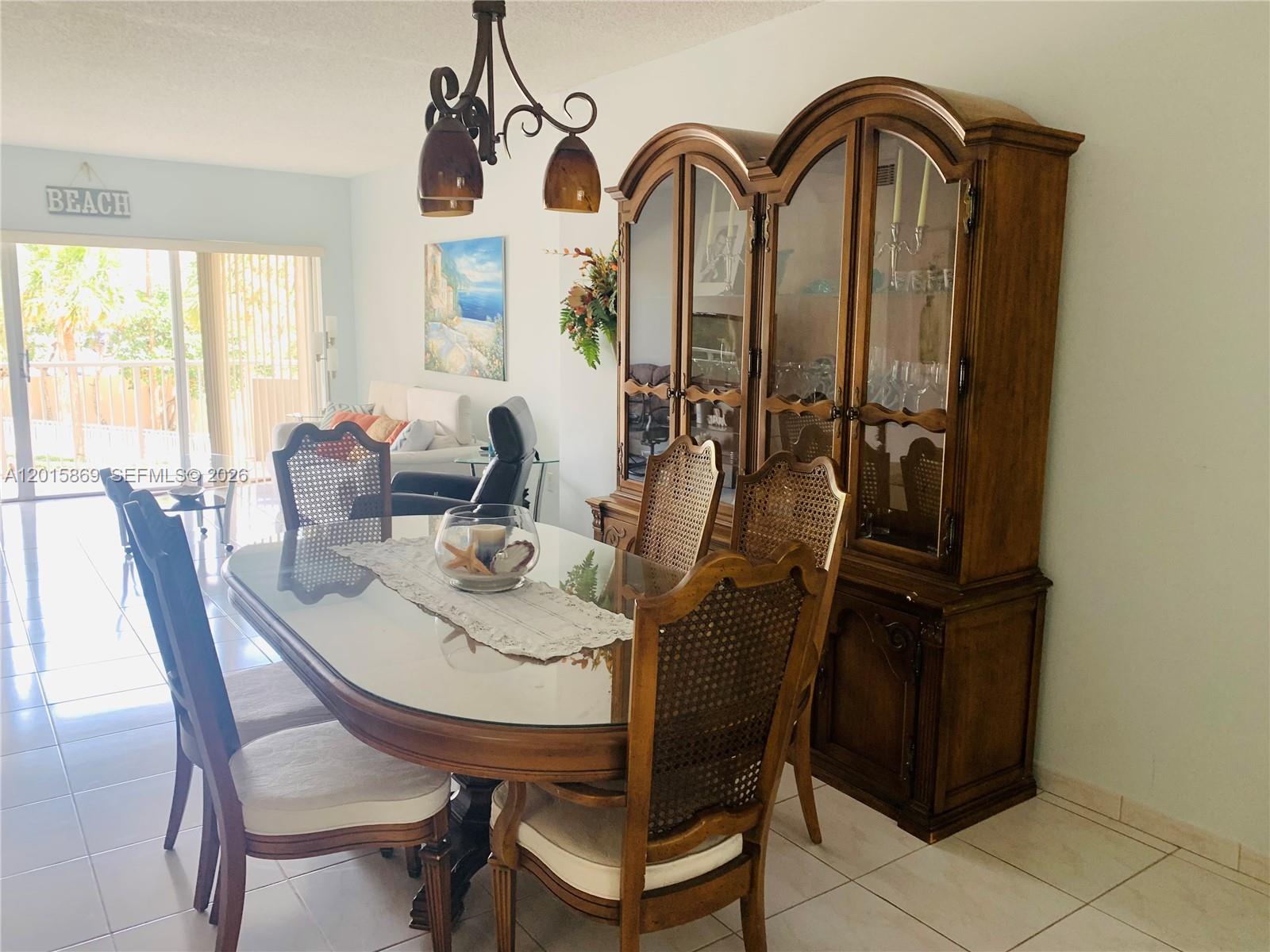 A dining room features a glass-topped table, cane-back chairs, and a large wooden china cabinet — 1985 S Ocean Dr, Hallandale Beach FL 33009, HALLANDALE BEACH, FL
