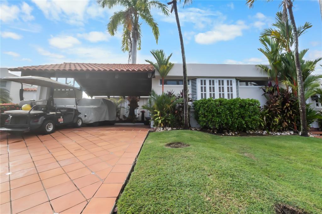 A single-story house with a tiled carport, a golf cart, and a landscaped front lawn — AD5 CALLE BALEARES, HUMACAO, PR