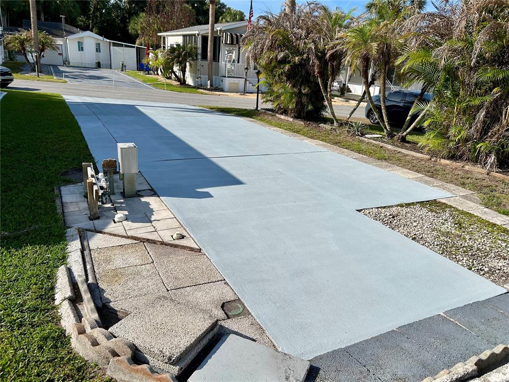 A paved driveway leads to a mobile home with palm trees and landscaping — 1112 FEATHER LANE, BOWLING GREEN, FL