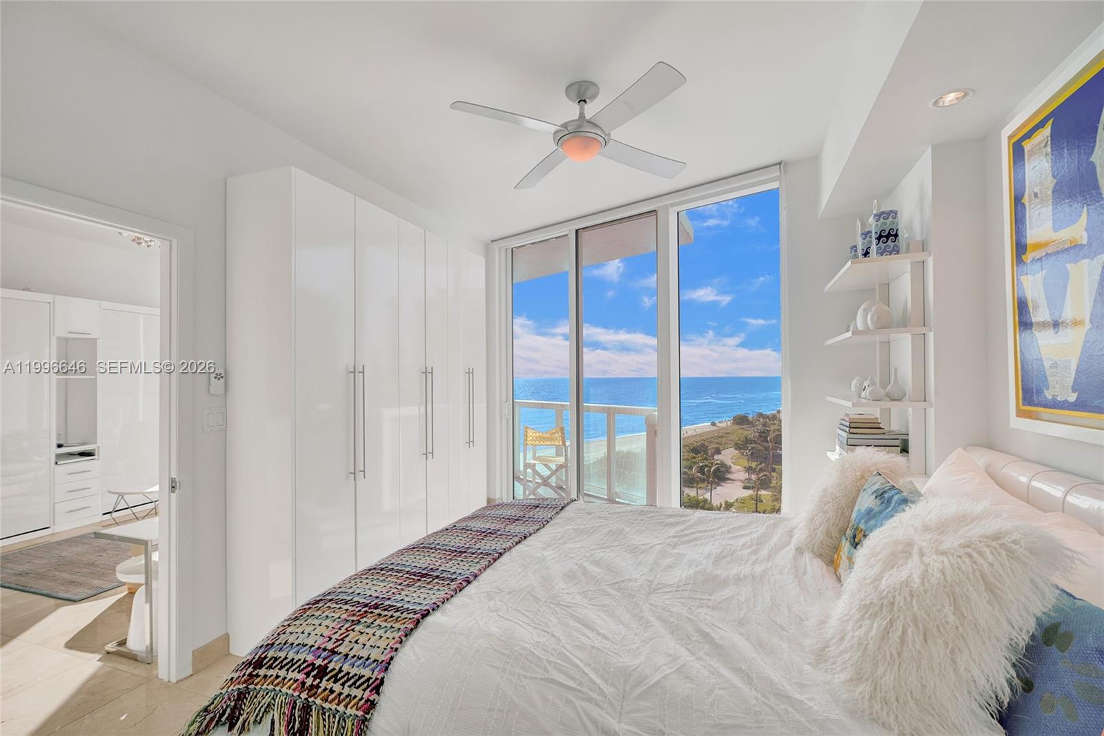 A bedroom features a white wardrobe, a bed with a textured throw, and ocean views — 6515 Collins Ave # 804, Miami Beach FL 33141, MIAMI BEACH, FL