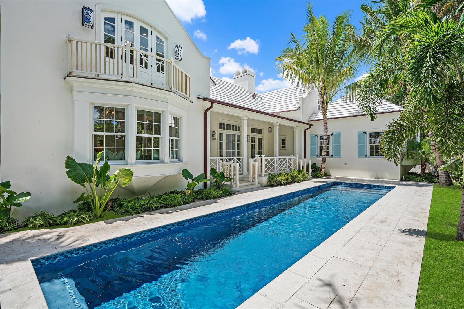 A white house with a balcony and blue shutters overlooks a rectangular backyard swimming pool — 269 Jamaica Lane, Palm Beach FL 33480, PALM BEACH, FL