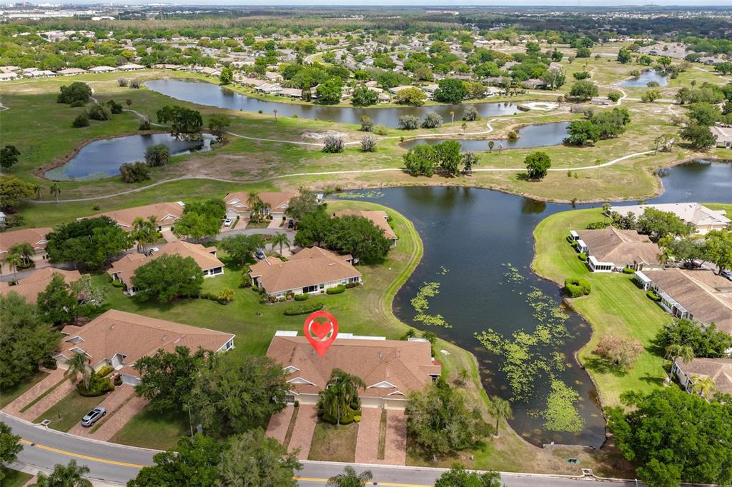 An aerial view shows a residential building with a red heart icon near a lake — 2020 NANTUCKET DRIVE, SUN CITY CENTER, FL