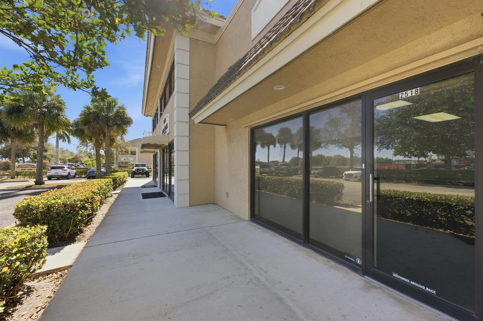 A sidewalk runs along the exterior of a commercial building with glass storefront doors — 2518 SE Willoughby Boulevard # 2518, Stuart FL 34994, STUART, FL