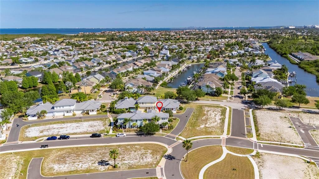 An aerial view shows a residential neighborhood with a marked house near a canal — 5536 LUMINAR POINTE LANE, APOLLO BEACH, FL