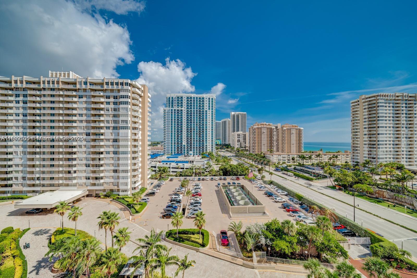 An elevated view shows a large parking lot between several high-rise apartment buildings near the ocean — 1985 S Ocean Dr # 15A, Hallandale Beach FL 33009, HALLANDALE BEACH, FL