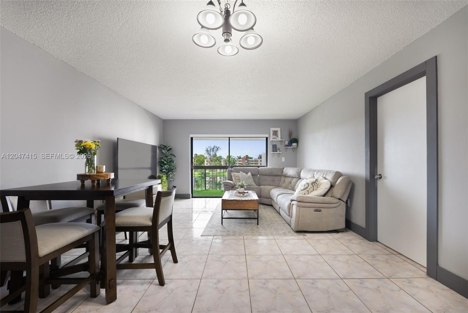 A living and dining area features tile floors, a sectional sofa, and a sliding glass door — 1300 SW 122nd Ave # 2, Miami FL 33184, MIAMI, FL
