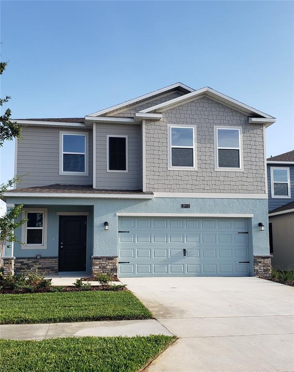 A two-story house features a light blue stucco lower level, gray siding, and a garage — 3910 AMERS LOOP, HAINES CITY, FL