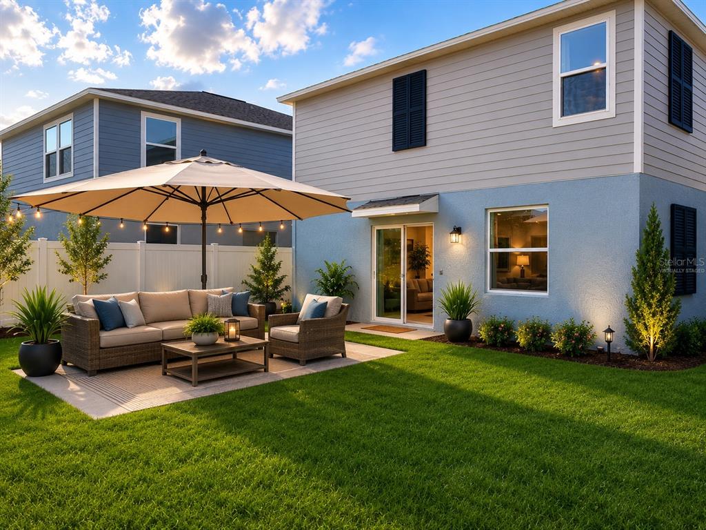 A backyard patio features a wicker sofa set, a large umbrella, and string lights — 3910 AMERS LOOP, HAINES CITY, FL