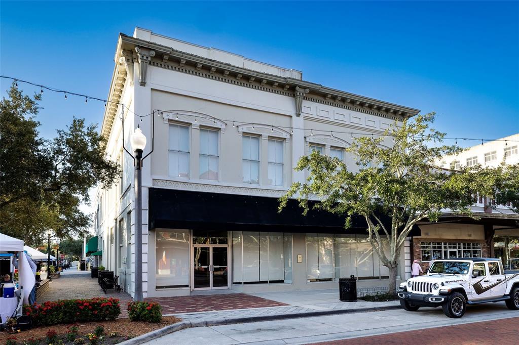 A two-story commercial building with a black awning and a white Jeep parked outside — 121 E 1ST STREET UNIT 101, SANFORD, FL