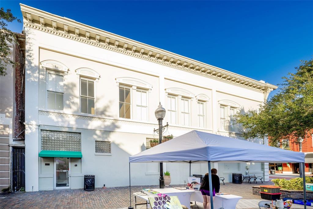 A two-story white building with a decorative cornice and a green awning over the entrance — 121 E 1ST STREET UNIT 101, SANFORD, FL