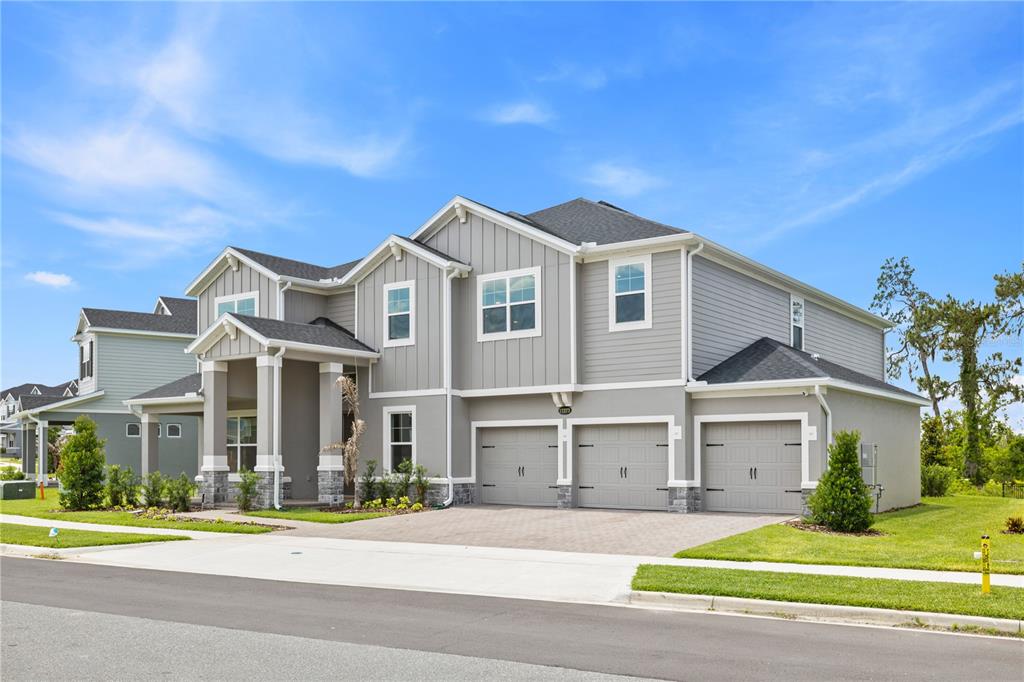 A two-story house with gray siding, a three-car garage, and a covered front entryway — 17372 GLOSSY POMELO WAY, WINTER GARDEN, FL