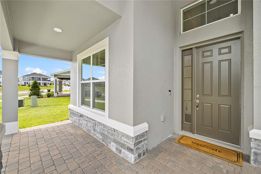 A two-story gray house with a three-car garage and a covered front entryway — 17372 GLOSSY POMELO WAY, WINTER GARDEN, FL
