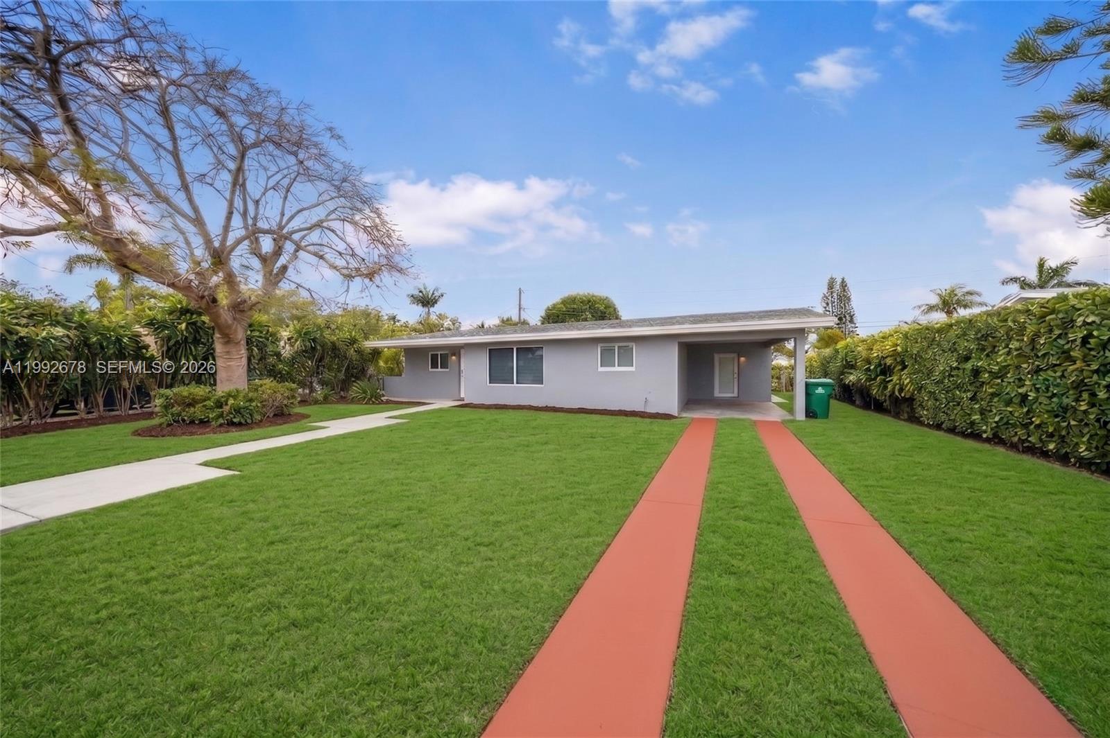 A single-story gray house features a red-striped driveway and a large front lawn — 17860 SW 110th Ct, Miami FL 33157, MIAMI, FL