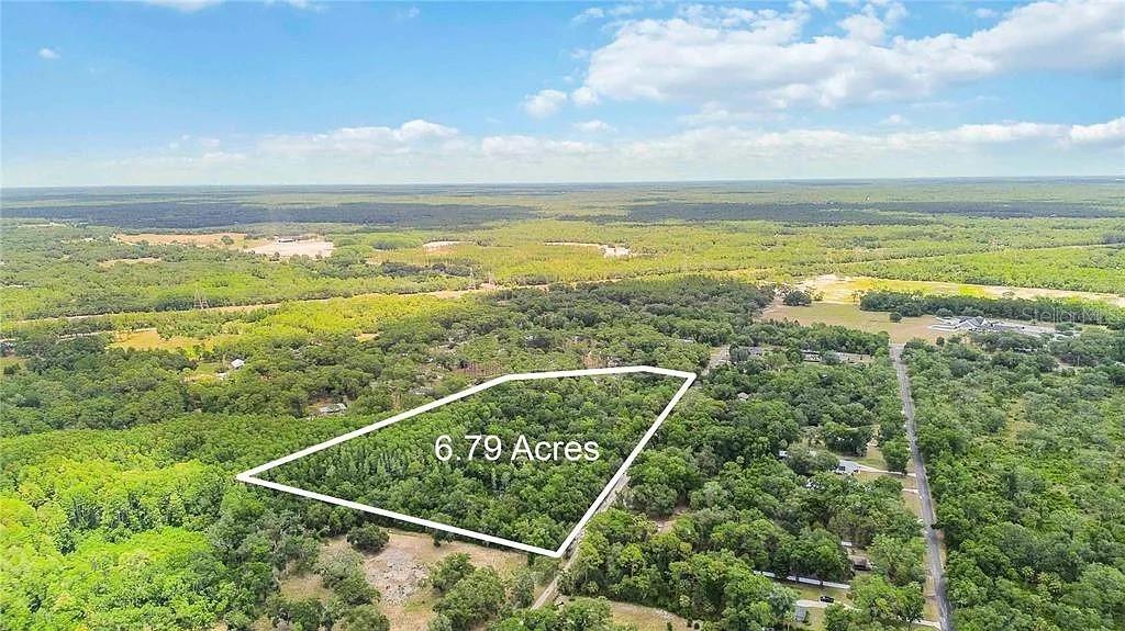 An aerial view shows a wooded 6.79-acre plot of land outlined in white — 5018 N ANDRI DRIVE, CRYSTAL RIVER, FL