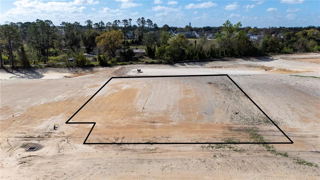 An aerial view shows a cleared, rectangular residential lot outlined in black on sandy ground — 32862 DUNNE ROAD, SAN ANTONIO, FL