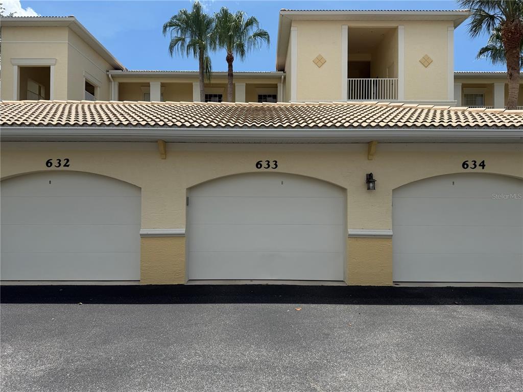 Three garage doors labeled 632, 633, and 634 are set into a tan stucco building — 600 GARDENS EDGE DRIVE UNIT 633, VENICE, FL