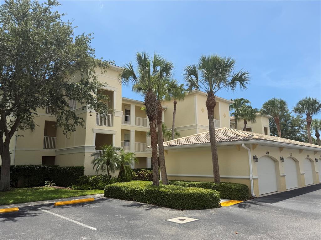 A multi-story apartment building with a row of garages and palm trees in front — 600 GARDENS EDGE DRIVE UNIT 633, VENICE, FL