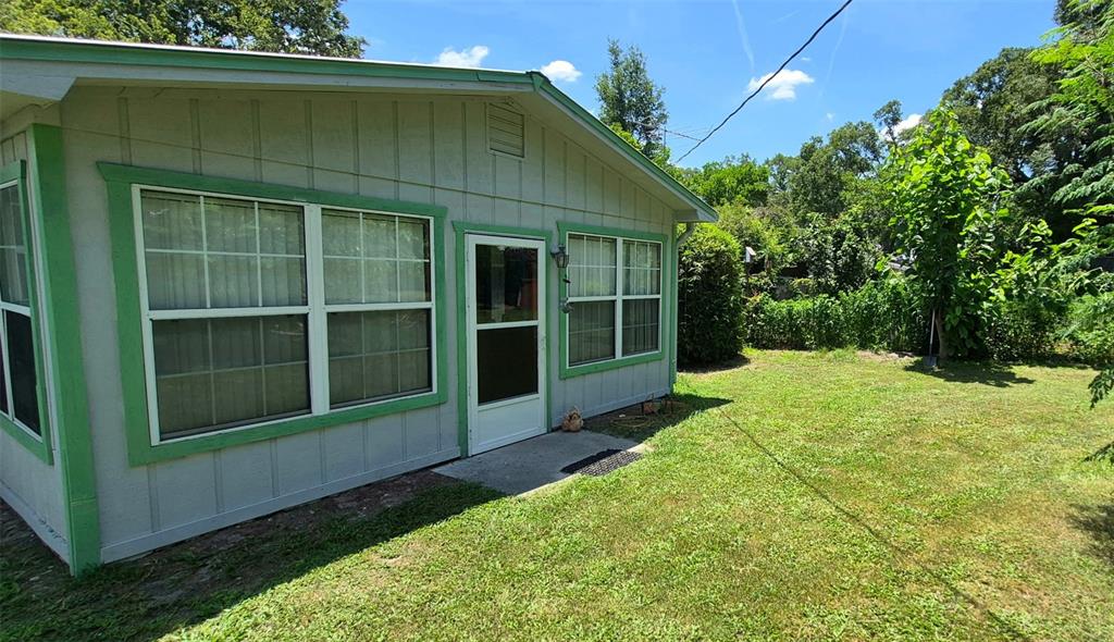 The exterior of a light gray house features green trim, a screen door, and windows — 17144 NW 239TH TERRACE, HIGH SPRINGS, FL