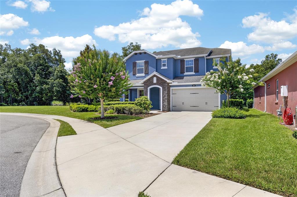 A two-story blue house with a stone-accented entrance and a two-car garage — 3506 WICKET FIELD ROAD, LUTZ, FL