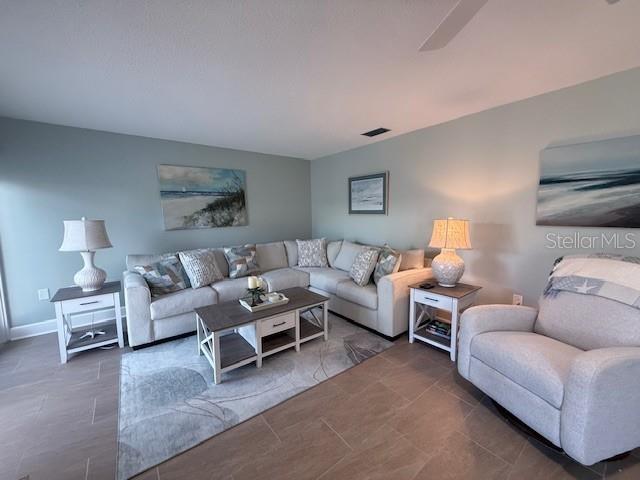 A living room features a sectional sofa, a recliner, and two end tables with lamps — 143 WHISPERING SANDS DRIVE UNIT N/A, SARASOTA, FL