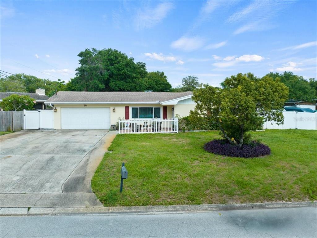 A single-story house with a white garage, a front porch, and a large tree — 1560 BEL KEENE DRIVE, CLEARWATER, FL