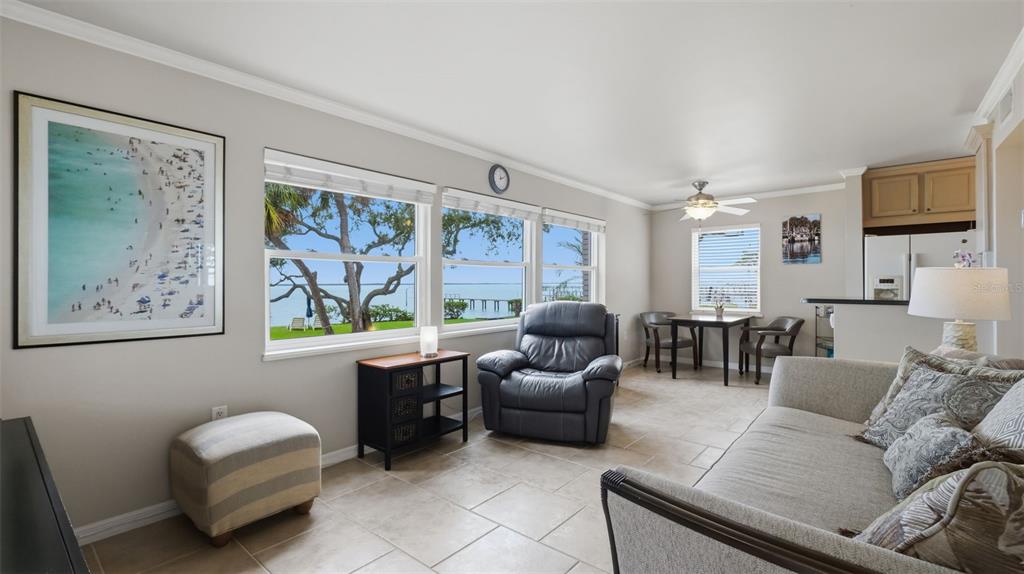 A patio with two chairs, a small table, and a door with a number sign — 1101 VICTORIA DRIVE UNIT 1, DUNEDIN, FL