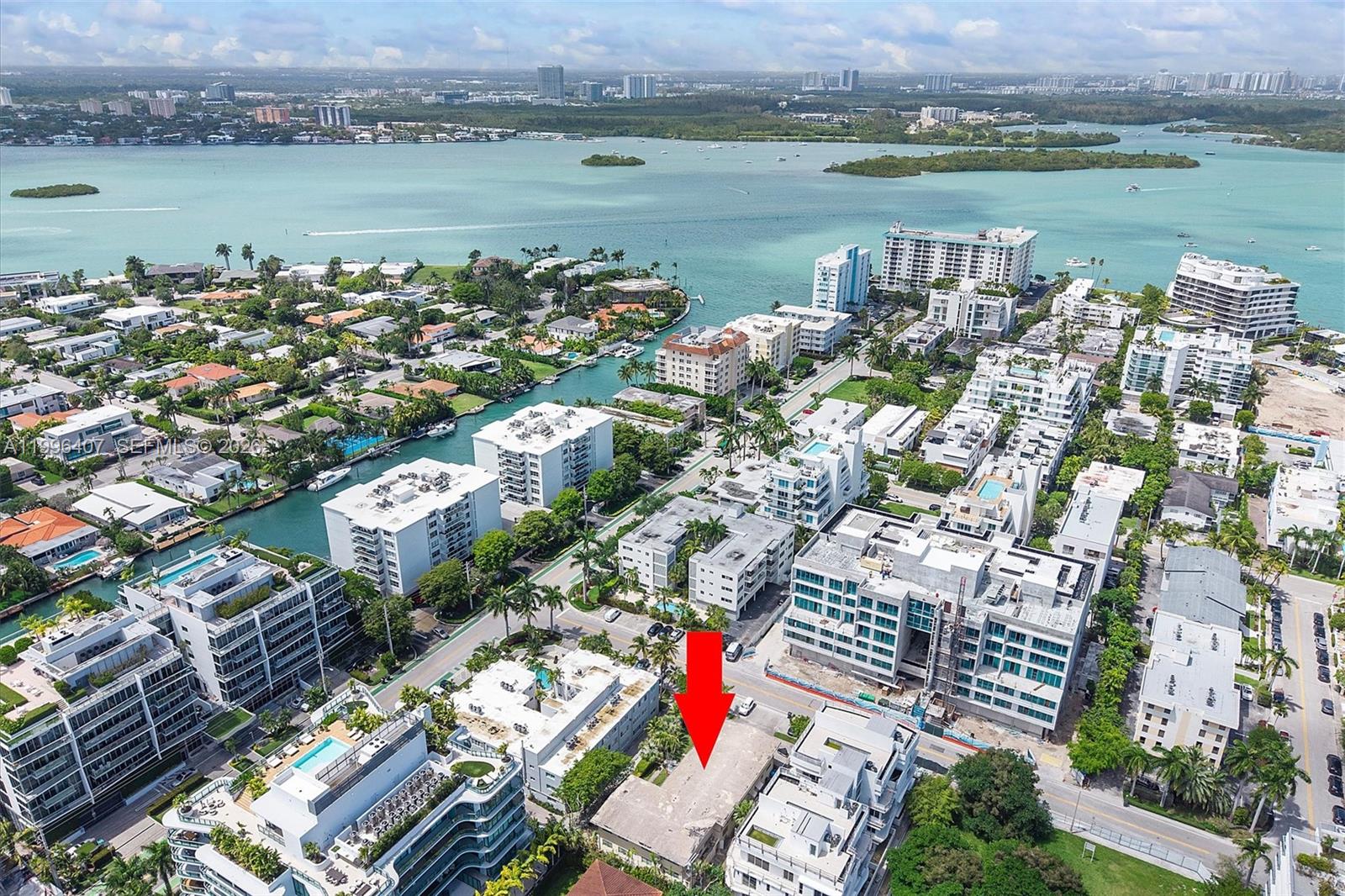 An aerial view shows a low-rise apartment building marked with a red arrow — 1160 100th St, Bay Harbor Islands FL 33154, BAY HARBOR ISLANDS, FL