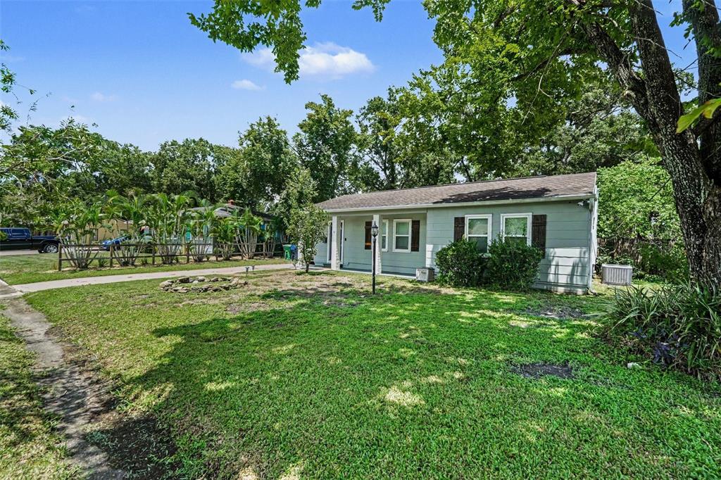 A light green single-story house with a dark roof sits on a grassy lot — 1509 W BARR DRIVE, TAMPA, FL