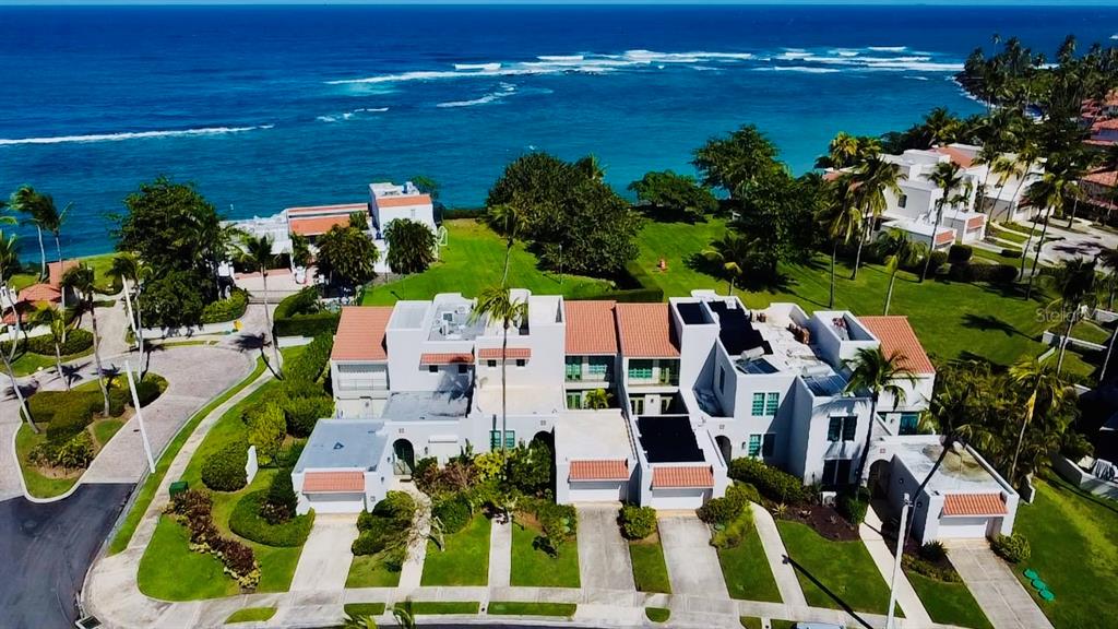 An aerial view of a multi-unit residential building with red tile roofs near the ocean — Calle Arecife DORADO REEF UNIT P-65, DORADO, PR
