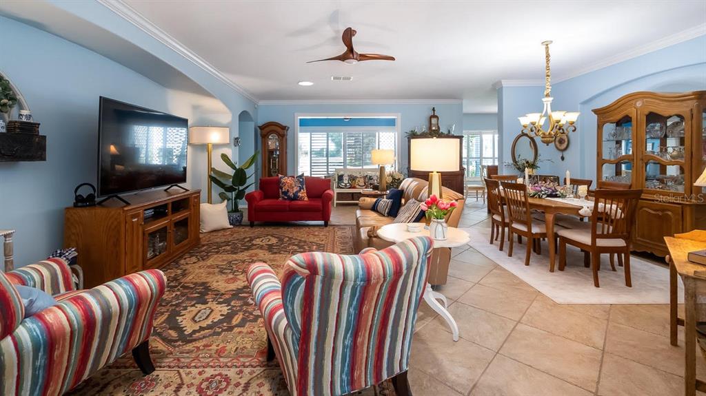 A living and dining room area features light blue walls, tile flooring, and traditional furniture — 4010 HAMMERSMITH DRIVE, CLERMONT, FL