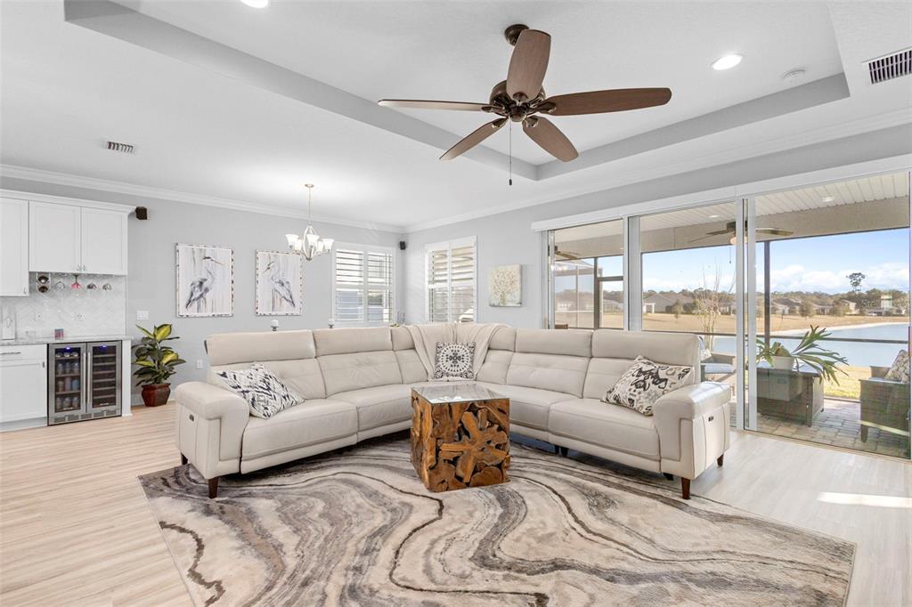 A living room features a white sectional sofa, a wooden coffee table, and sliding glass doors — 1188 VICTORIA HILLS DRIVE N, DELAND, FL