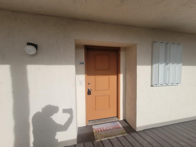 An exterior view of a tan apartment door numbered 206 with a welcome mat — 5917 Via Vermilya # 206, Lake Worth FL 33462, LAKE WORTH, FL