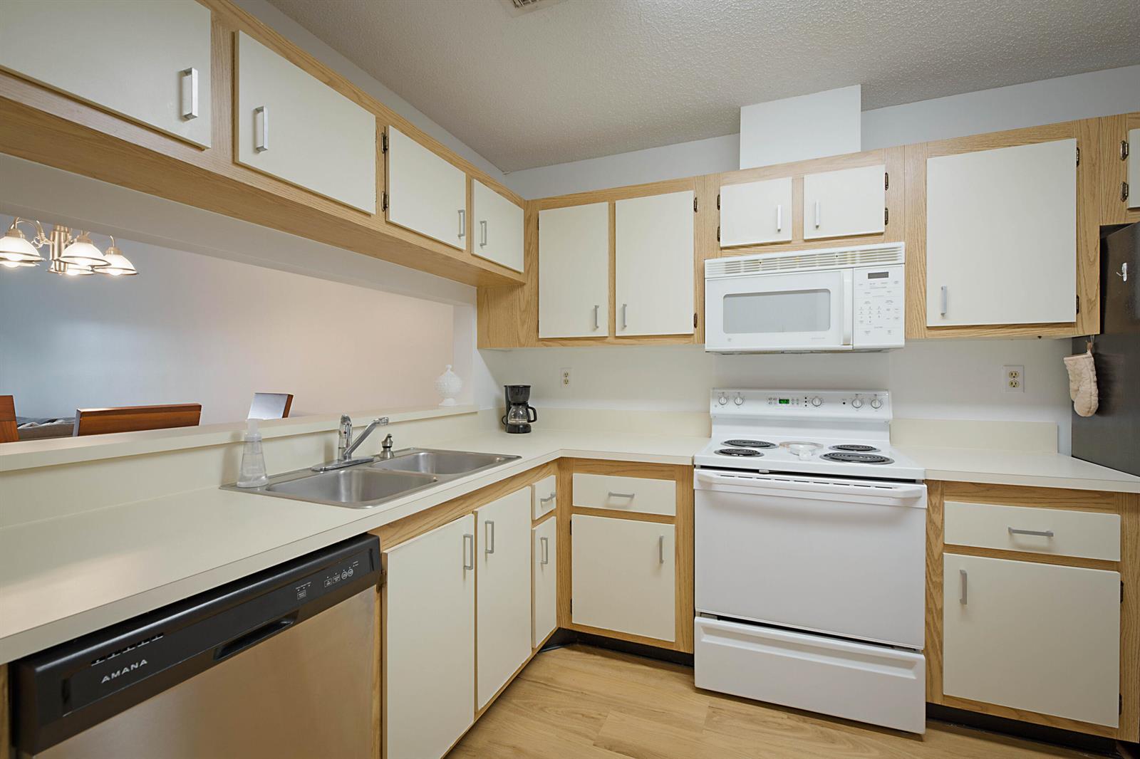 A kitchen features white appliances, light wood cabinets, and a double sink with laminate countertops — 903 Harbour Pointe Way, FL 33413, FL