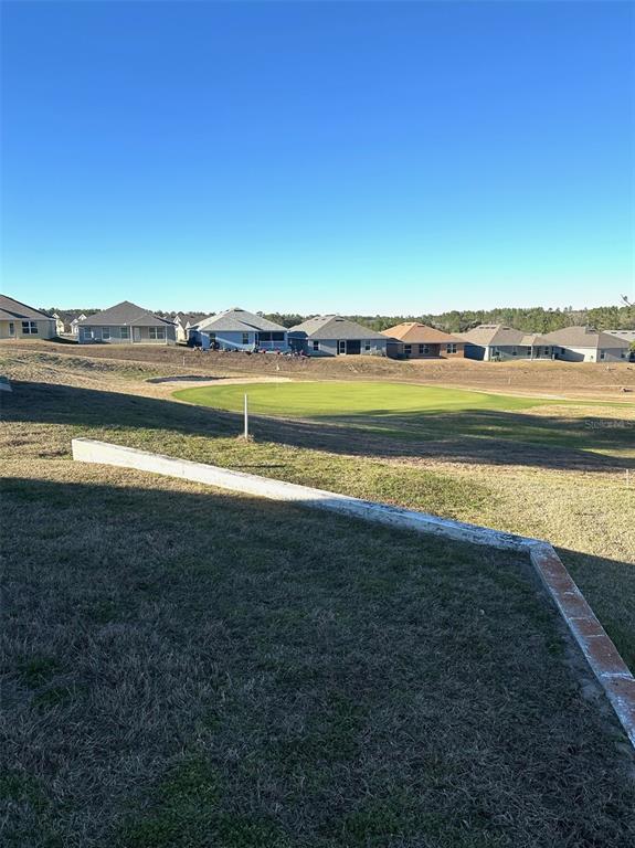 A view of a golf course green situated behind a row of suburban houses — 251 W REXFORD DRIVE, BEVERLY HILLS, FL