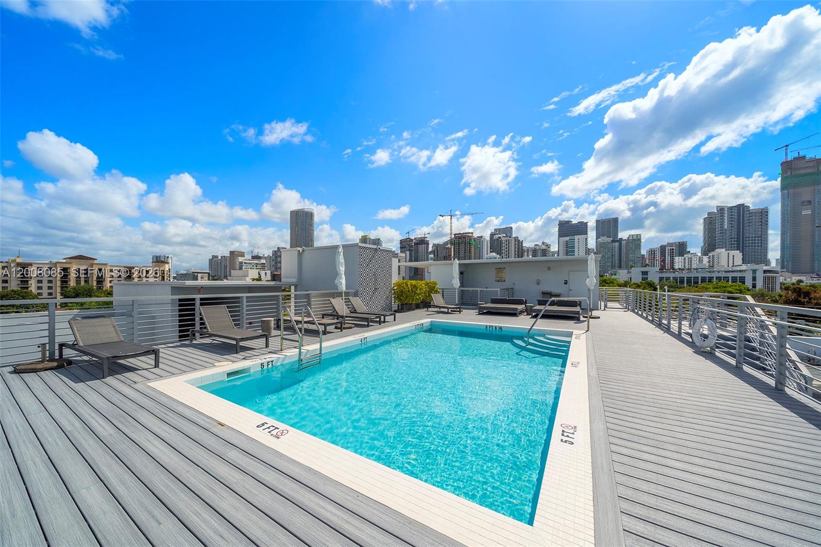 An open-concept kitchen and dining area features white cabinets, wood-grain accents, and marble-look tile flooring — 545 SW 11th St # 208, Miami FL 33129, MIAMI, FL