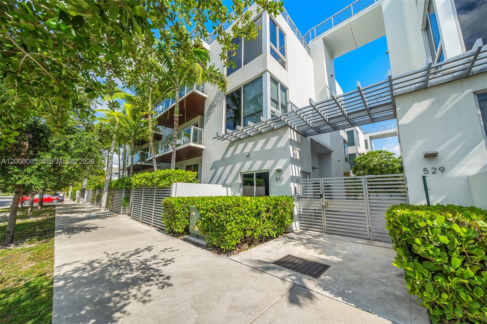 A bedroom features a bed, a desk with a chair, and a large window view — 545 SW 11th St # 208, Miami FL 33129, MIAMI, FL