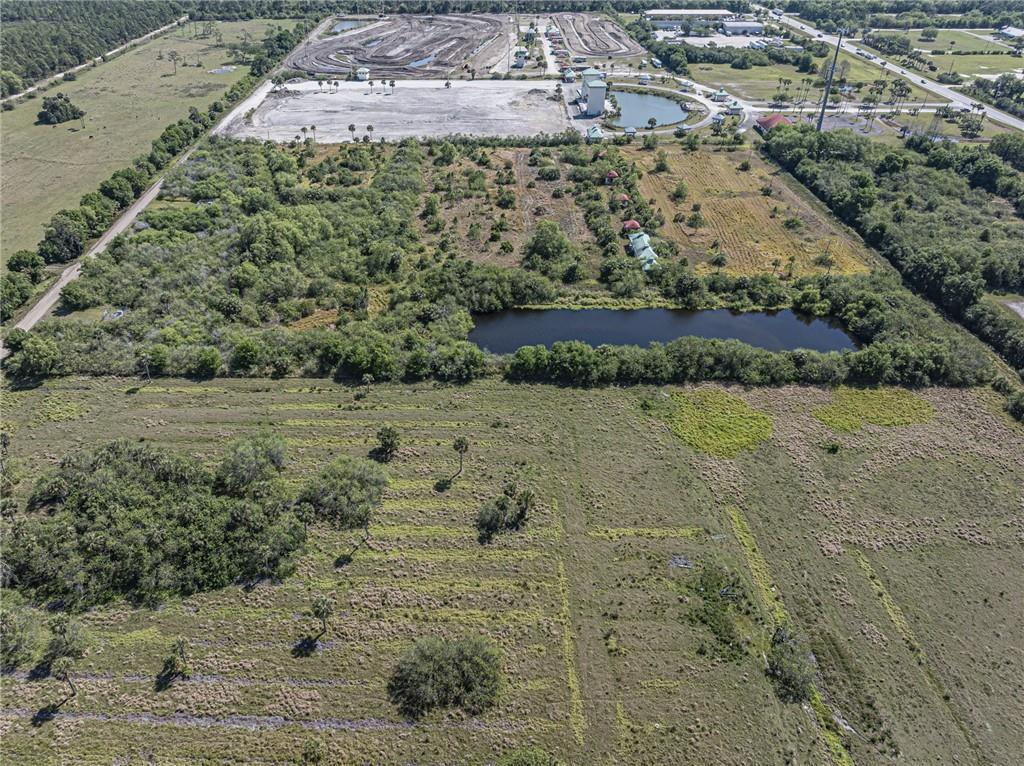 An aerial view shows a large, mostly undeveloped plot of land with a small pond — 9555 Mesa Park C Boulevard, Fellsmere FL 32948, FELLSMERE, FL