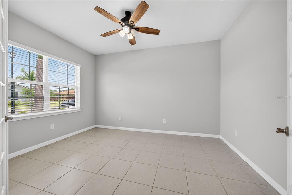 An empty room with light gray walls, tile flooring, and a ceiling fan — 20458 BANDERA PLACE, VENICE, FL