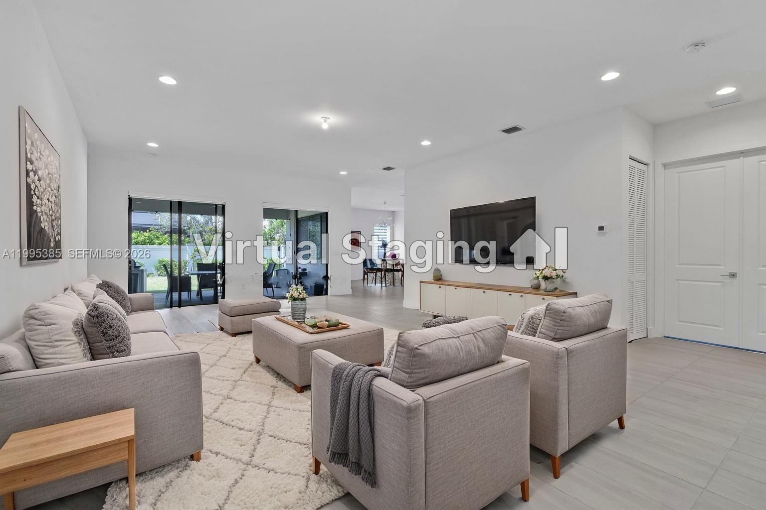 A living room with light gray furniture, a large rug, and a wall-mounted television — 4528 SW 178th Ave, Miramar FL 33029, MIRAMAR, FL