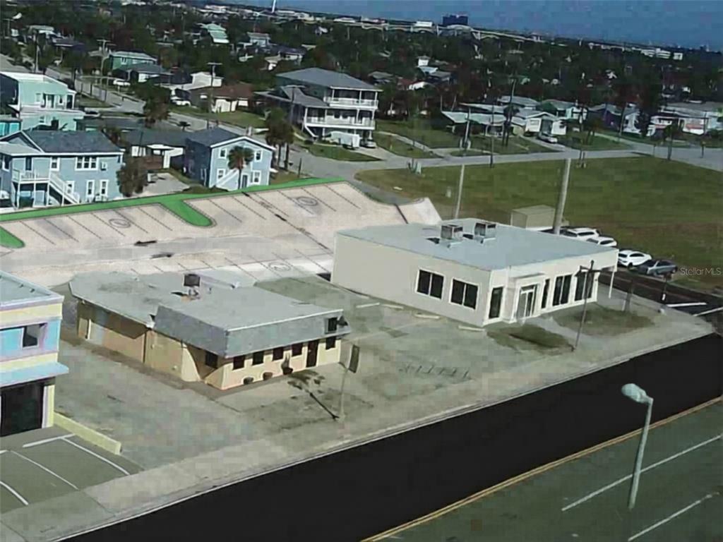 An aerial view shows two commercial buildings with flat roofs and adjacent parking lots — 2006 S ATLANTIC AVENUE, DAYTONA BEACH, FL
