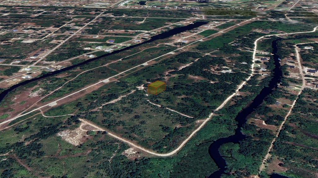 An aerial view shows a vacant, rectangular lot highlighted in orange within a wooded area — 1461 PALSGRAVE DRIVE, PUNTA GORDA, FL