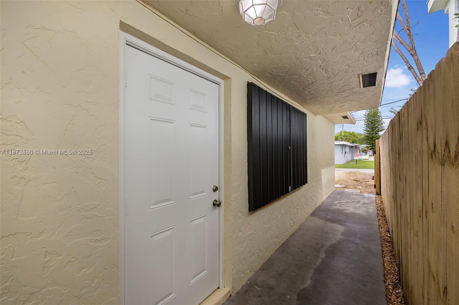 A white door and black window shutters are on the exterior wall of a house — 2033 Dewey St, Hollywood FL 33020, HOLLYWOOD, FL